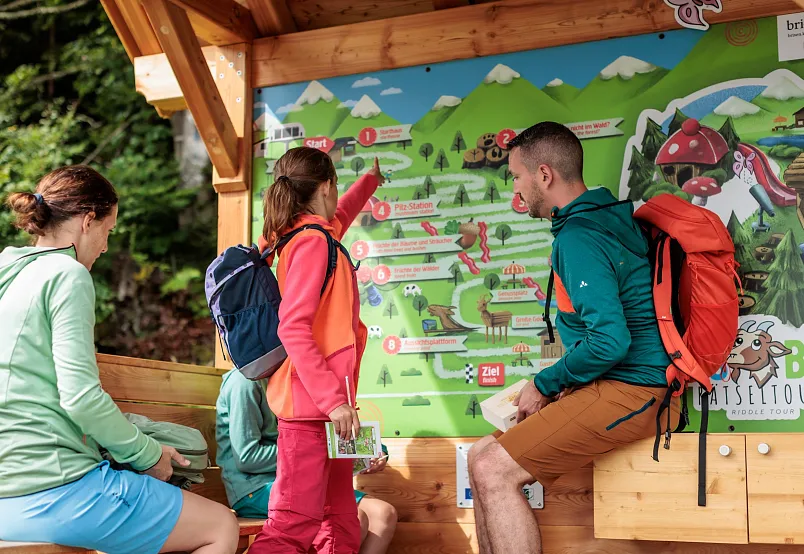 Gruppe von Wanderern studiert eine Wanderkarte in den Alpen.