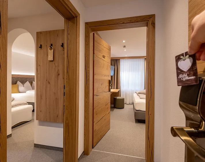 Moderne hotelkamer in Tirol met houten interieur en twee aparte bedden.
