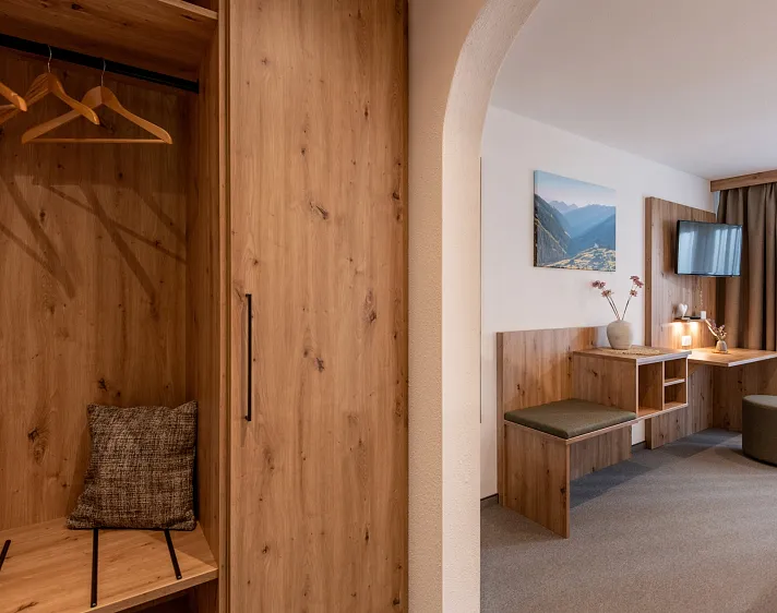 Modernes Hotelzimmer mit Holzmöbeln, TV und Schreibtisch.