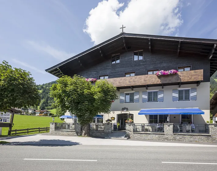 Traditionelles Haus in Tirol mit Holzbalkon und Blumenschmuck.