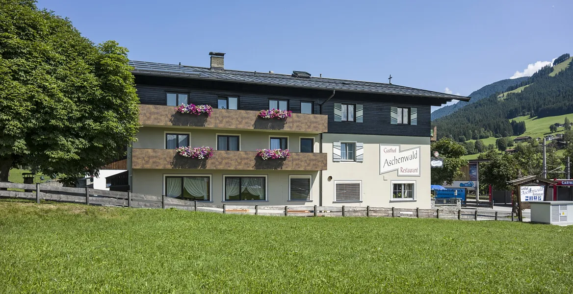 Ein traditionelles Gasthaus mit Holzbalkon und Garten in den Tiroler Alpen.