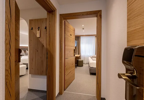 Moderne hotelkamer in Tirol met houten interieur en twee aparte bedden.